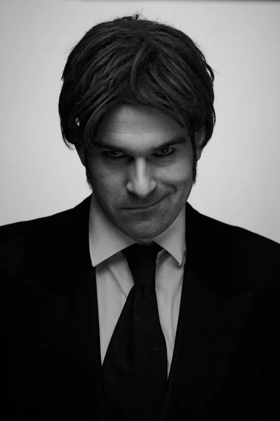 Bestatter Peter Pansen in Schwarz-Weiß-Foto, trägt einen schwarzen Anzug und schwarze Krawatte, guckt wie ein Psychopath in die Kamera